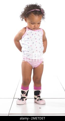 Girl wearing vest, pants and slippers, 16 months Stock Photo