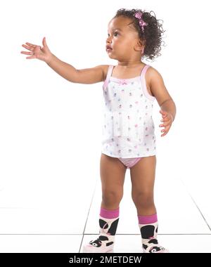 Girl wearing vest, pants and slippers, 16 months, Stock Photo