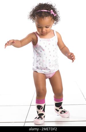 Girl wearing vest, pants and slippers, 16 months Stock Photo