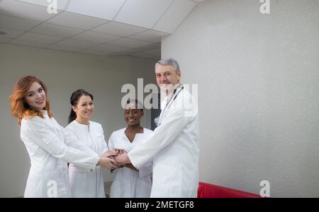 clinic, profession, people, healthcare and the concept of medicine - a happy group of doctors or doctors in a hospital corridor Stock Photo