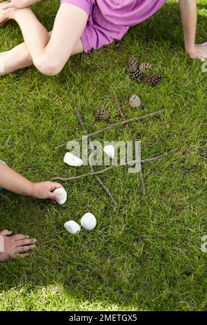Noughts and crosses game using pebbles and cones Stock Photo