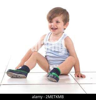 Boy sitting on the floor, 20 months Stock Photo