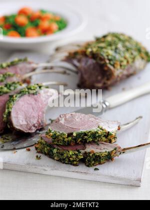 Roast rack of lamb with herb crust, cut in slices Stock Photo