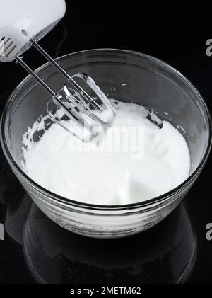 Close-up, whisking an egg white with small metal whisk