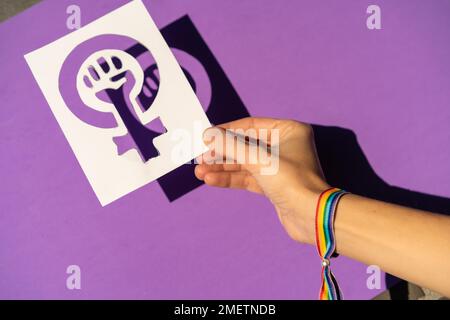 A woman holding a drawing in a vindication in favor of equality between men and women, purple background, fighting in favor of women, Female Force Stock Photo