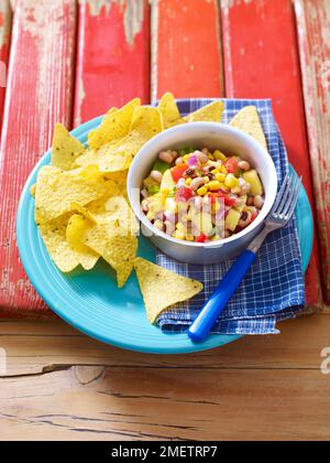 Tropical Texas caviar, black-eyed beans with vegetables and mango, served with tortilla chips Stock Photo