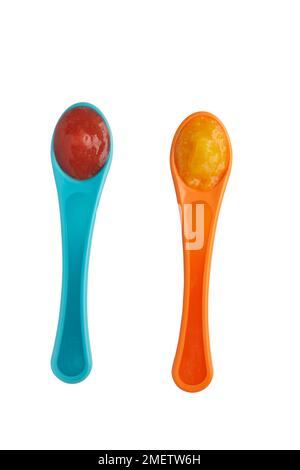 Raspberry puree and apple and apricot puree on baby spoons Stock Photo