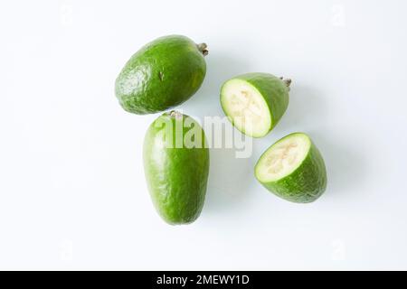 Pineapple guava fruit on white background, with one cut in half and showing the flesh Stock Photo