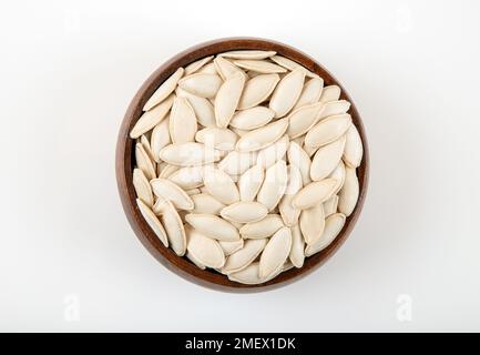 A bowl full of pumpkin seeds on white background Stock Photo