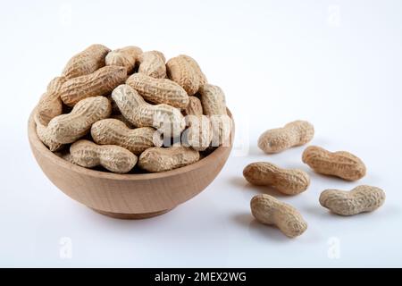 Bowl full of shelled peanuts on white background Stock Photo