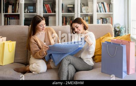 Happy pretty surprised millennial european ladies shopaholic in sweaters with shopping bags from store Stock Photo