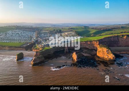 Ladram Bay, Otterton, UK.  24th January 2023.  UK Weather.   View from the air of the red sandstone sea stacks and cliffs at Ladram Bay at Otterton near Sidmouth in Devon on a cold sunny afternoon.  Picture Credit: Graham Hunt/Alamy Live News Stock Photo