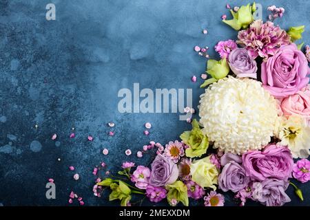 Beautiful  flowers on vintage blue background. Festive floral concept with clean space for text. Top view. Stock Photo