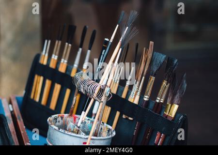 A set of hair paintbrushes in an artist's case and a pot of oil paint Stock Photo