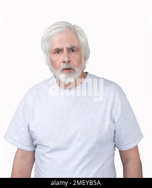 Vertical shot of an old man looking startled or frightened.  Standing from the waist up.  Isolated on white. Stock Photo