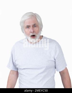 Vertical shot of an astonished or startled looking old man with white hair on a white background.  Standing from the waist up. Stock Photo