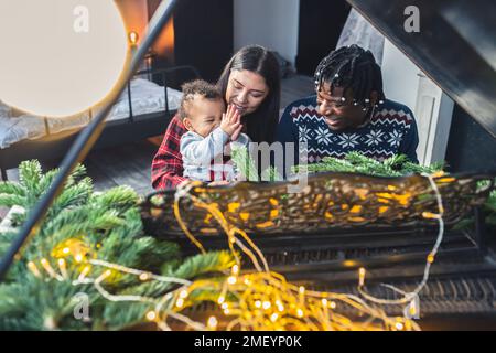 Happy smiling family of three playing piano on a Christmas day. High quality photo Stock Photo