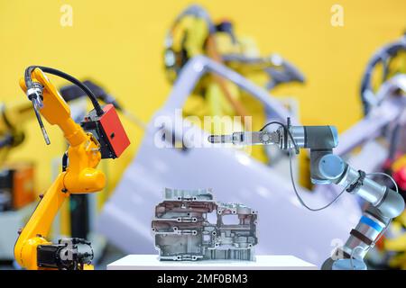 Industrial robotic welding and gripping robot working with metal part on blurred smart car factory background Stock Photo