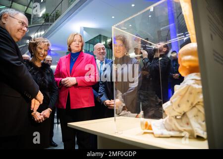 24 January 2023, Berlin: Dani Dayan (l-r), Chairman of the Holocaust Memorial Yad Vashem in Jerusalem, Lore Mayerfeld, contemporary witness, Bundestag President Bärbel Bas (SPD), Ron Prosor, Ambassador of Israel to Germany, and Ruth Ur, Executive Director of the Friends of Yad Vashem and curator of the exhibition, look at the doll named Inge by Lore Mayerfeld at the opening of the exhibition 'Sixteen Objects - Seventy Years of Yad Vashem' on the occasion of the Memorial Day for the Victims of National Socialism in the Paul-Löbe-Haus of the German Bundestag. This is dressed in the paj Stock Photo