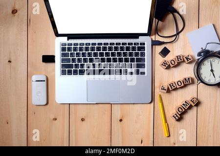 Laptop on wooden table, accessories hardware and wood cube Open computer laptop portable on white blank display for work at home Stock Photo