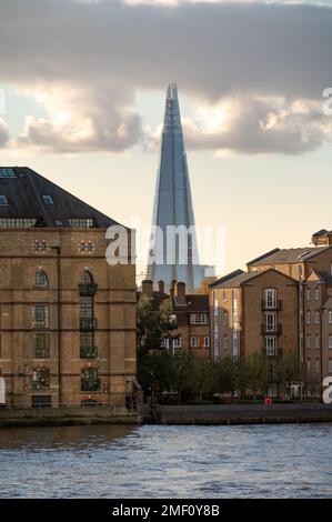 LONDON - November 4, 2020: The Shard seen between old warehouses and modern apartments with the River Thames in the foreground Stock Photo