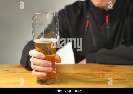 mug with beer in hand on the table and the background of the person Stock Photo