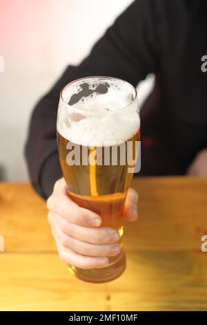 mug with beer in hand on the table and the background of the person Stock Photo