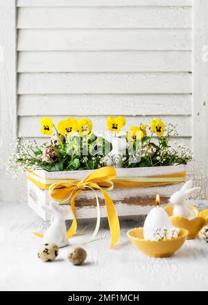Handmade decoration made with yellow viola flowers in the old vintage wooden box for Easter. Copy space. Floristic concept. Stock Photo