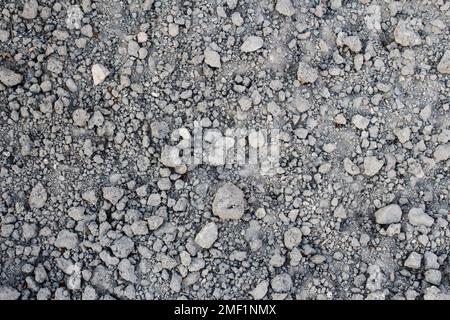 Dry soil. Defocus stony grey desert soil texture. Gray dry ground with small stones. Close-up from above. Out of focus. Stock Photo