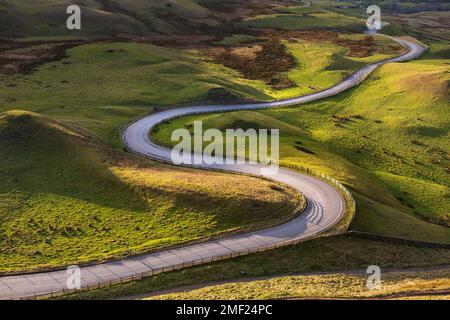 Long winding road leading through lush green British countryside on a Summer afternoon in The Peak District, UK. Stock Photo