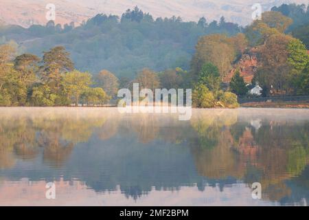 Reflections in water on a Spring morning at Rydal Water in the Lake District, UK. Beautiful British scenery with relaxing atmosphere. Stock Photo