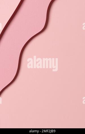 Abstract colored paper texture background. Minimal paper cut composition with layers of geometric shapes and lines in pastel pink colors. Top view Stock Photo