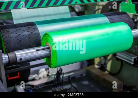 Automatic plastic bag making machine - roller with green polyethylene film Stock Photo