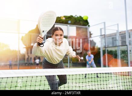 Young sporty woman playing paddle tennis outdoors Stock Photo