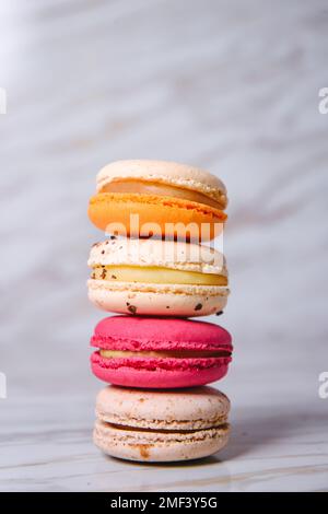 Pink, orange and beige macaroons on marble style. A beautiful and beautiful French dessert. Stock Photo