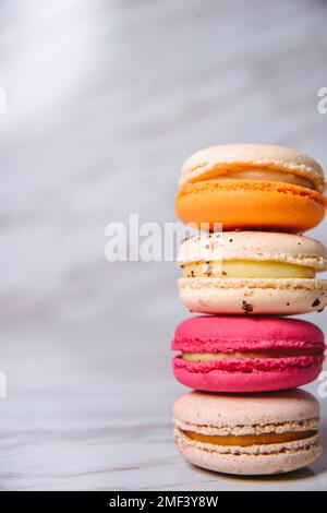 Pink, orange and beige macaroons on marble style. A beautiful and beautiful French dessert. Stock Photo