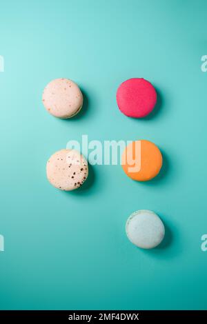 Colorful macarons. Small French cakes. Sweet and colorful french macarons on a blue background. Gift for Valentine's Day Stock Photo