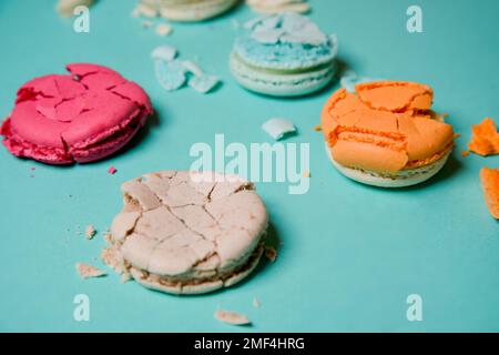 Crushed, broken macaron, French colored dessert on a blue background Stock Photo