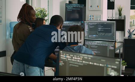 Database admins collaborating on group project compiling algorithm for new cloud computing user interface on computer. Multiethnic team of software engineers developing html script code. Stock Photo