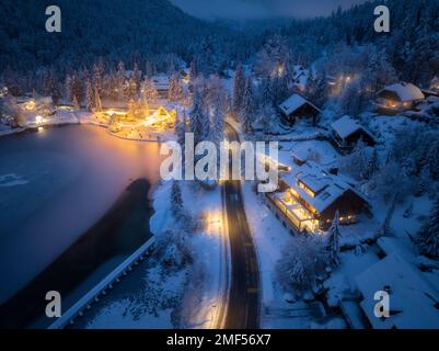 Aerial view of town in snow, road, forest, lake and houses Stock Photo
