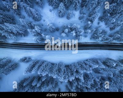Aerial view of mountain road in fairy forest in snow in winter Stock Photo