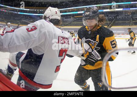 Pittsburgh, United States. 25th Mar, 2023. Washington Capitals right wing  Nicolas Aube-Kubel (96) knocks Pittsburgh Penguins defenseman Kris Letang  (58) to the ice as Washington Capitals center Dylan Strome (17) shoots and
