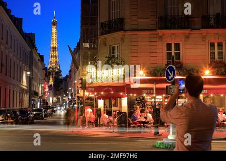 Night view of Eiffel Tower and Cafe Le Recrutement in the corner of Rue Saint-Dominique and Boulevard de la Tour-Maubourg with vehicles taillight trails.Paris.France Stock Photo