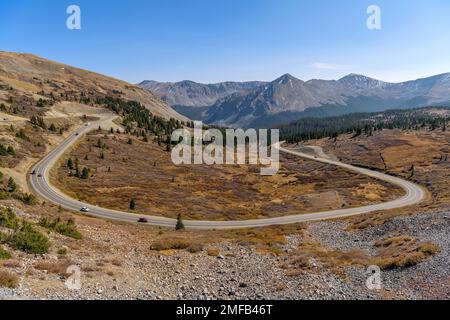 Autumn Mountain Road - A panoramic overview of a winding mountain road at east of summit of Cottonwood Pass on a sunny Autumn day. Colorado, USA. Stock Photo