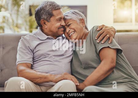 Happy, love and senior couple on a sofa hugging, bonding and relaxing together in their living room. Happiness, laugh and elderly man and woman Stock Photo