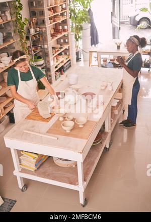 Pottery business and workshop people sculpting together for creative process and productivity with tools top view. Focus, concentration and skill of Stock Photo