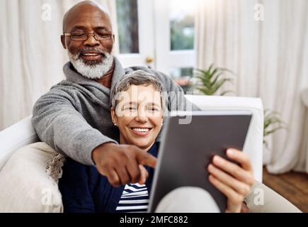 Show me that video again, those people are hilarious. an affectionate senior couple using a tablet while relaxing on the sofa at home. Stock Photo