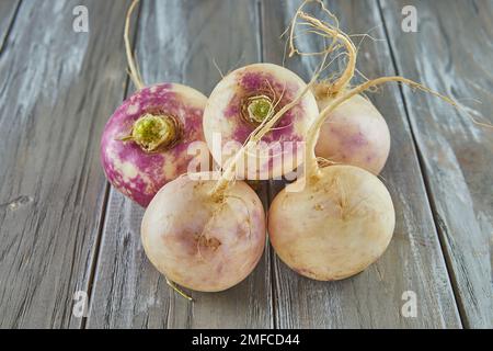 Fresh purple turnip stacked on wooden gray background Stock Photo