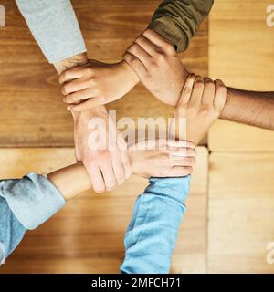Solidarity. High angle shot of a group of unrecognizable university students holding one anothers wrists as a show of solidarity. Stock Photo
