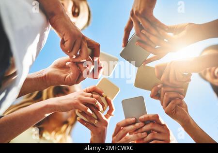 Getting connected today is very easy. unrecognizable people using smartphones outside. Stock Photo